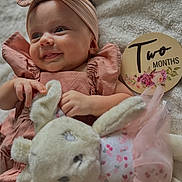 Vanni is registered to the contest to win money with this photo: baby, infant, smile, headband, plush_toy, bunny, blanket, milestone_sign, two_months, pink_clothing, soft_texture, cute, child, portrait, lying_down, hand, face, happy, indoors, cozy