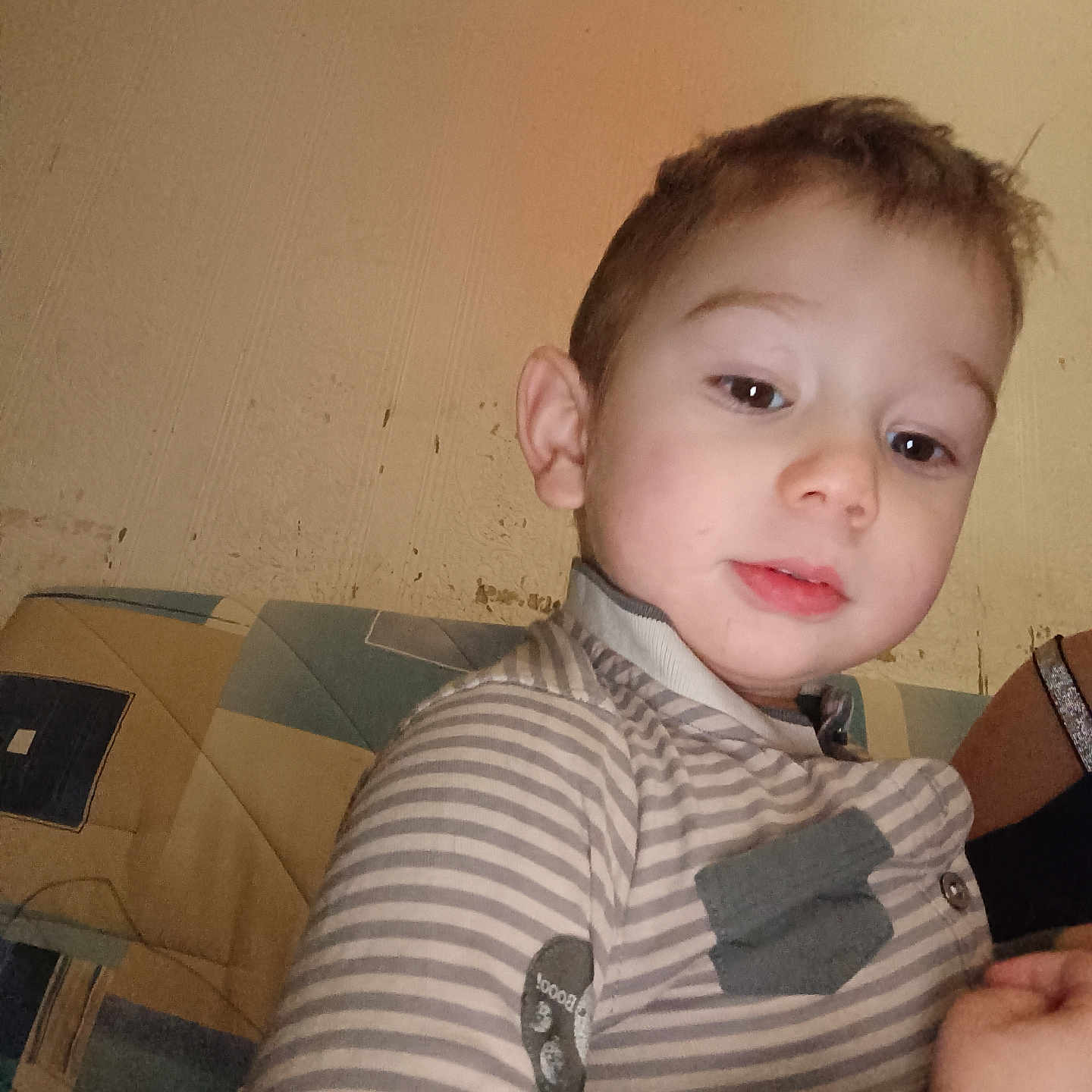 Gabriel participe au concours pour gagner de l'argent avec cette photo : baby, bodypart, clothing, couch, face, finger, furniture, hand, head, homedecor, knitwear, longsleeve, pants, person, photography, portrait, shirt, sitting, sleeve, sweater