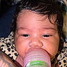baby, bottle, curly_hair, close_up, feeding, leopard_print, blanket, infant, cute, face, skin, hand, nipple, sleepy, child, indoors, person, young, soft_light, portrait