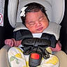 baby, newborn, sleeping, car_seat, safety_harness, bow, infant_clothing, lemon_pattern, feet, peaceful, cute, child, seat_padding, resting, tiny_hands, tiny_feet, infant, portrait, indoors, soft_lighting