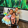Arabella joined the competition — help win amazing prizes! children, baby, stroller, indoor, peace_sign, lollipop, bottle, toddler, smiling, dress, shorts, bow, floor, wall, window, plant_mural, bench, toy, happy, family