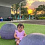 toddler, child, park, sunset, grass, playground, purple, outdoor, trees, sky, clouds, building, bench, people, funny_face, clothing, nature, recreation, daylight, cute