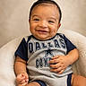 baby, smiling, infant, child, onesie, dallas_cowboys, blue, gray, sitting, cute, happy, portrait, indoor, soft_texture, cozy, plush, hand, face, head, young