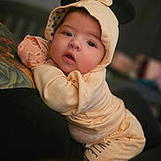 Michaela is registered to the contest to win money with this photo: baby, infant, cute, hooded_outfit, mouse_ears, bow, curious, cushion, soft_lighting, portrait, indoors, child, young, clothing, closeup, face, expression, warm_colors, cozy, resting