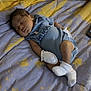 baby, sleeping, newborn, blue_onesie, mittens, socks, bed, bedding, yellow, gray, pattern, infant, child, peaceful, resting, indoors, blanket, soft, cute, portrait