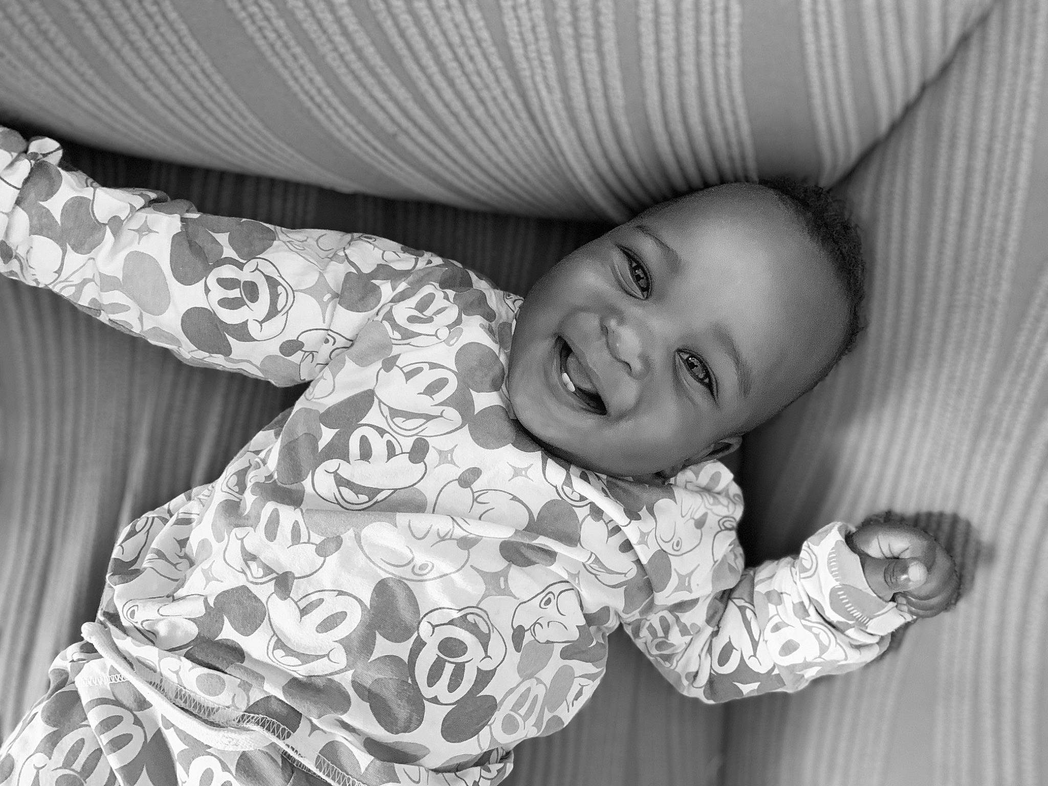 Kyron a rejoint le concours — aidez-le/la à gagner de superbes lots ! arm, baby, black, black_and_white, comfort, eye, facial_expression, flash_photography, hand, happy, human, mammal, mouth, person, product, skin, sleeve, smile, standing, style