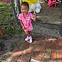 Kaylani is registered to the contest to win money with this photo: child, girl, pink_outfit, rainbow_patch, balloons, yellow_balloons, white_balloons, outdoor, brick_path, chain_link_fence, grass, shoes, smiling, happy, playful, bracelet, concrete_floor, pink_chair, person, sunlight