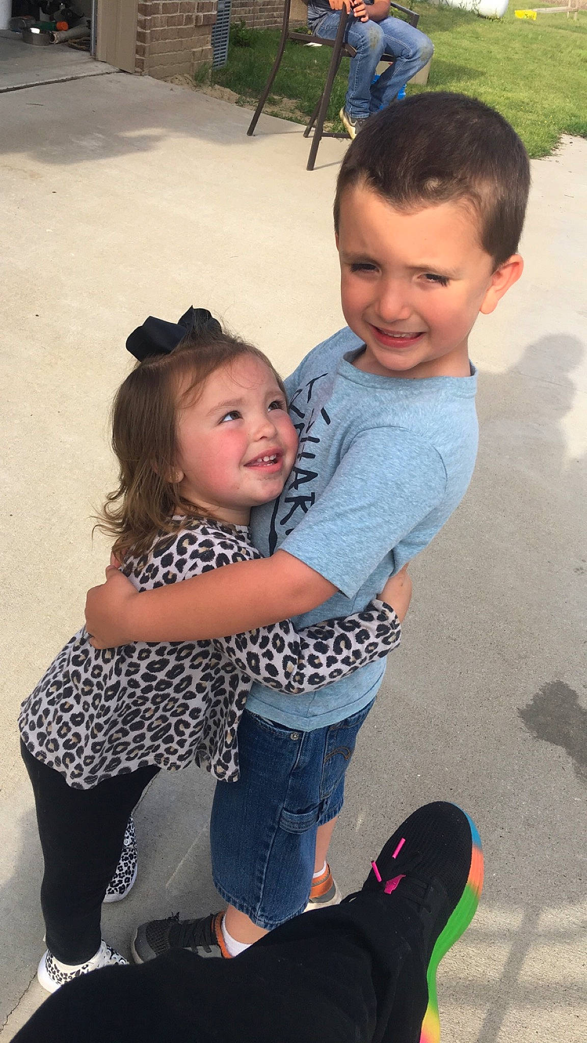 Kaydence is registered to the contest to win money with this photo: child, face, footwear, fun, happy, head, hug, interaction, jeans, joy, leg, outerwear, people, person, photography, shoulder, sibling, sitting, skin, smile