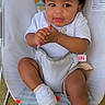 animal_print, baby, baby_rocker, cap, child, clapping_hands, colorful, curious, cute, happy, infant, outdoor, playful, seated, shorts, smiling, sneakers, white_shoes, white_tshirt, young_child