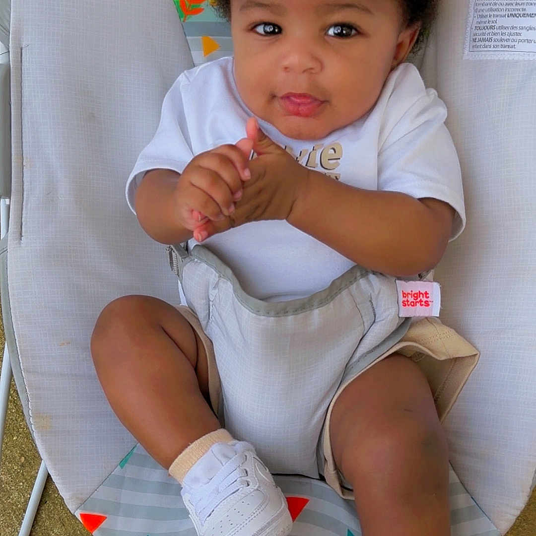 Seth Williams is registered to the contest to win money with this photo: baby, child, cap, white_shoes, sneakers, baby_rocker, clapping_hands, playful, curious, animal_print, seated, shorts, white_tshirt, outdoor, colorful, infant, smiling, cute, happy, young_child