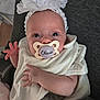 Olivia joined the competition — help win amazing prizes! baby, infant, pacifier, headband, flower, white_clothing, hand, face, eyes, skin, newborn, couch, blanket, soft_texture, indoors, portrait, cute, resting, child, person