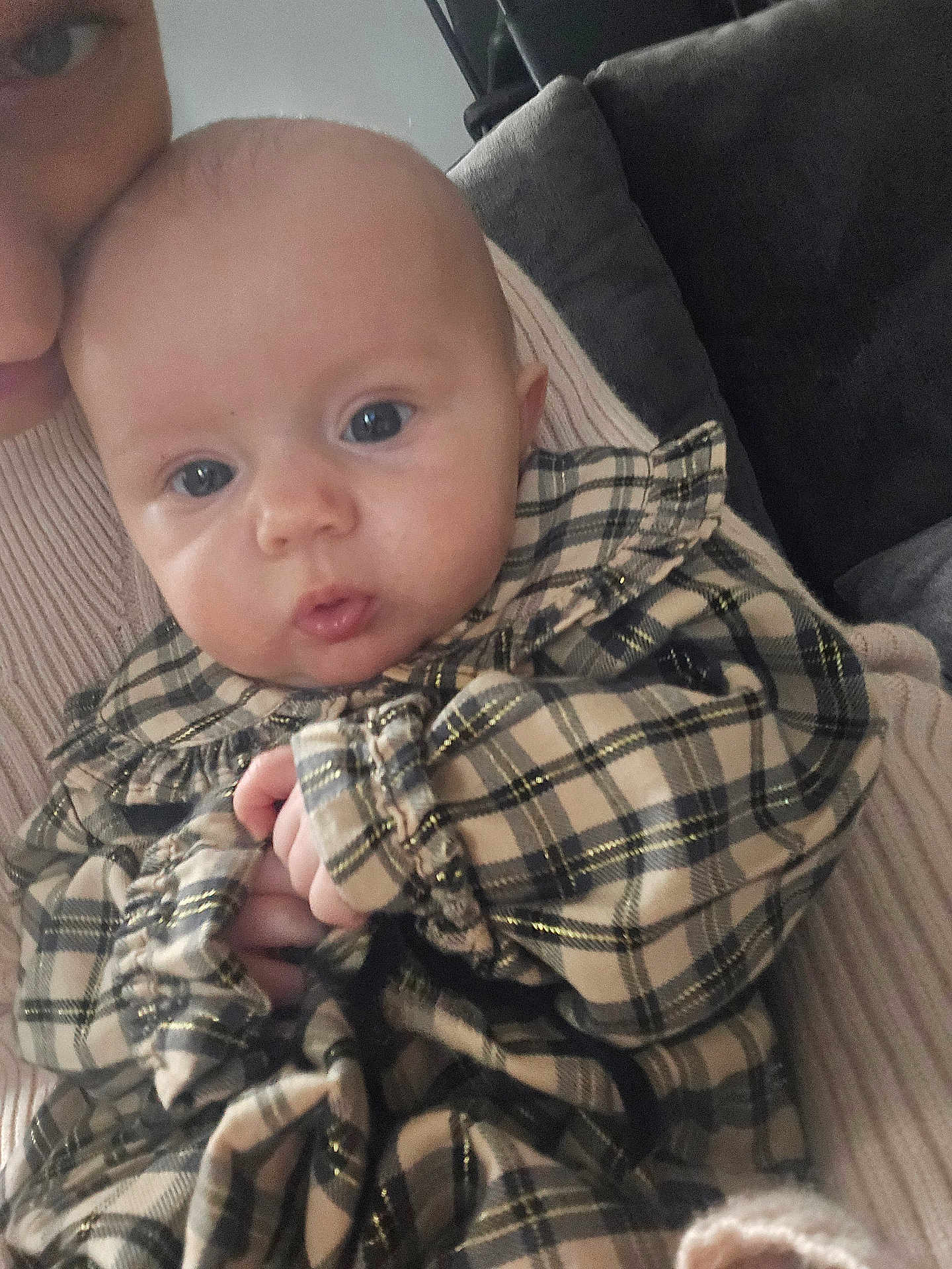 Olivia joined the competition — help win amazing prizes! baby, infant, child, plaid, clothing, person, face, hand, adult, holding, indoor, couch, fabric, cute, portrait, skin, eyes, head, warm, soft