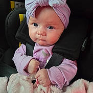 Olivia is registered to the contest to win money with this photo: baby, infant, car_seat, headwrap, pacifier, blanket, pink_clothing, child, seatbelt, cute, portrait, indoors, person, hands, face, baby_girl, soft_texture, warm, closeup, sitting