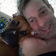 Zena joined the competition — help win amazing prizes! man, dog, face, smile, portrait, closeup, indoor, pet, friendship, cuddle, human, animal, brown_dog, tattoo, pillow, relaxation, casual, head, happy, companion