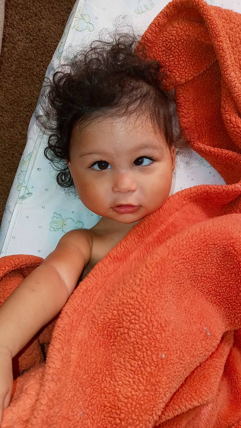 Omari is registered to the contest to win money with this photo: baby, beauty, cheek, child, close_up, eye, eyebrow, face, head, linens, lip, nose, peach, person, skin, smile, textile, toddler