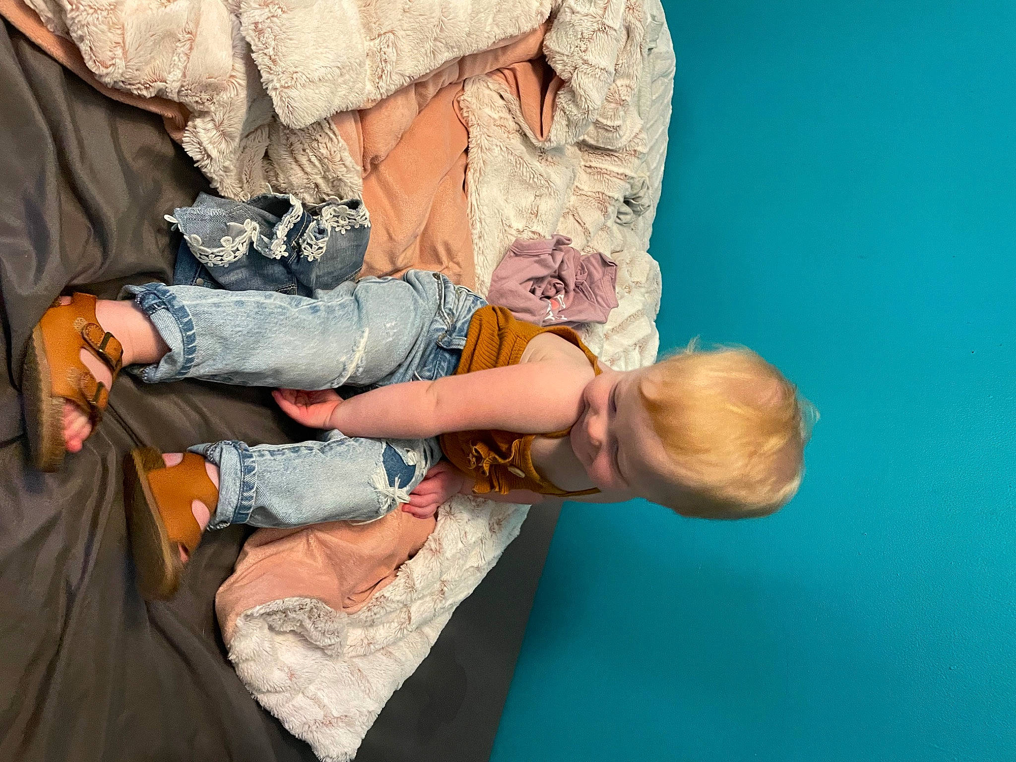 Alayna is registered to the contest to win money with this photo: baby, boot, camouflage, comfort, denim, elbow, finger, fun, gesture, happy, human_leg, jeans, joint, knee, leg, military_camouflage, person, sitting, t_shirt, toddler