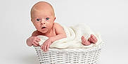 Makenzie joined the competition — help win amazing prizes! baby, basket, blanket, blue_eyes, cozy, cute, feet, hand, infant, knit_blanket, minimalist, newborn, photography, portrait, skin, studio_photo, surprised_expression, toes, white_background, wicker