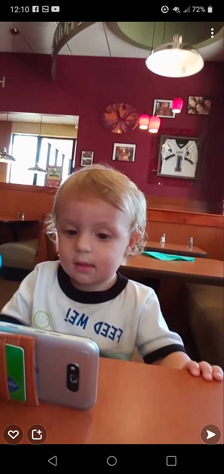 Gabriel joined the competition — help win amazing prizes! chair, child, chin, communication_device, computer, electronic_device, finger, fun, furniture, gadget, laptop, mobile_device, mobile_phone, person, personal_computer, picture_frame, portable_communications_device, t_shirt, table, technology