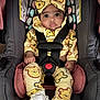 Myah is registered to the contest to win money with this photo: baby, car_seat, child, infant, yellow_clothing, headband, bow, straps, seatbelt, cute, drool, patterned_clothing, bear_print, white_booties, indoors, portrait, person, sitting, closeup, young_child