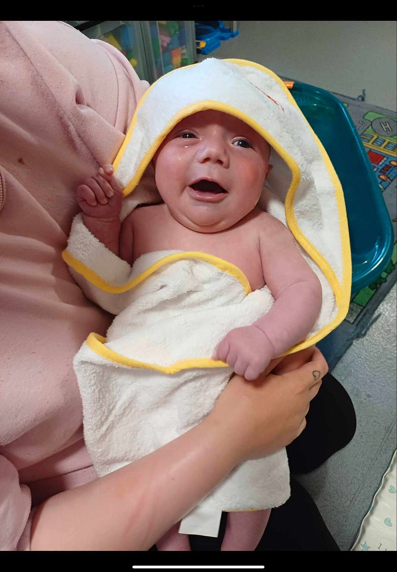 Brandon Lee Jnr is registered to the contest to win money with this photo: baby, towel, child, infant, holding, hand, pink_sleeve, smiling, indoor, person, play_mat, toys, cute, happy, skin, expression, young, wrapped, parent, care