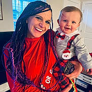 Tyden joined the competition — help win amazing prizes! woman, baby, smile, indoor, holiday_clothing, plaid, suspenders, santa_patch, braids, purple_hair, red_shirt, holding, window, natural_light, face, happy, child, person, home, joy