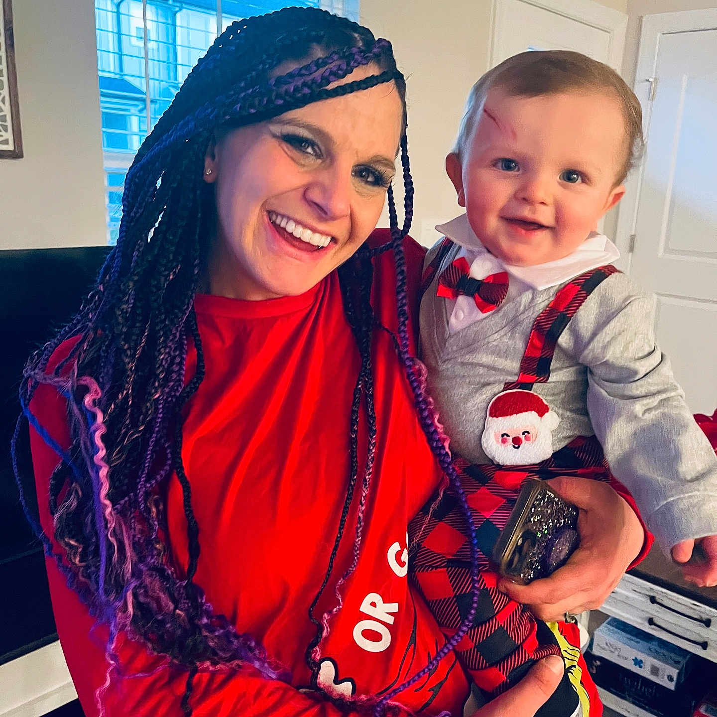 Tyden joined the competition — help win amazing prizes! woman, baby, smile, indoor, holiday_clothing, plaid, suspenders, santa_patch, braids, purple_hair, red_shirt, holding, window, natural_light, face, happy, child, person, home, joy