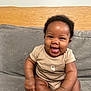 baby, smiling, infant, onesie, couch, gray_couch, happy, child, cute, sitting, indoor, portrait, young_child, skin, face, hand, foot, furniture, wood, cozy