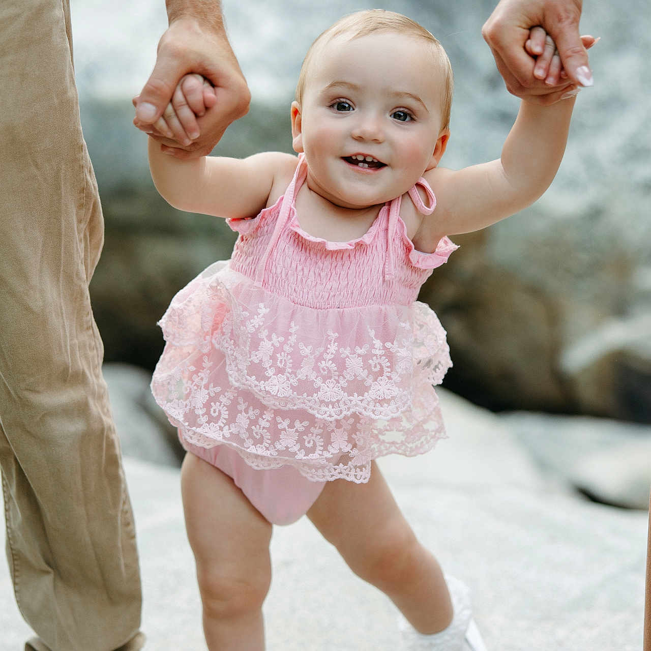 Remi is registered to the contest to win money with this photo: toddler, child, baby, pink_dress, walking, hands, tattoo, outdoor, rocks, shoes, white_shoes, smiling, happy, support, family, cute, young_child, nature, summer, playful