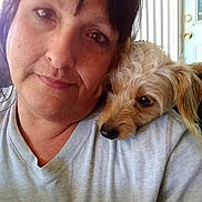 Babygirl is registered to the contest to win money with this photo: woman, dog, indoor, selfie, closeup, shoulder, pet, companion, casual, portrait, smile, curly_hair, light, door, gray_shirt, face, friendship, relaxed, human, animal