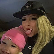 Annabelle joined the competition — help win amazing prizes! child, adult, selfie, pink_hat, blonde_hair, black_cap, tongue_out, smile, cozy_clothing, playful, face, portrait, indoor, casual, jacket, hat, person, funny_expression, long_hair, eyelashes