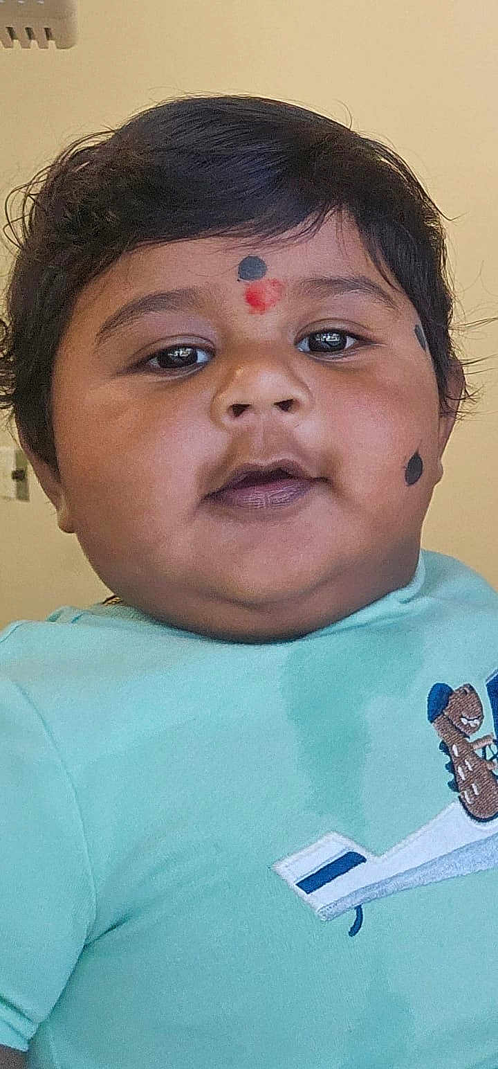 Ram joined the competition — help win amazing prizes! child, toddler, face, portrait, indoor, closeup, traditional_markings, blue_shirt, airplane_embroidery, cute, chubby_cheeks, black_hair, young_child, person, baby, head, expression, casual_clothing, skin, front_view