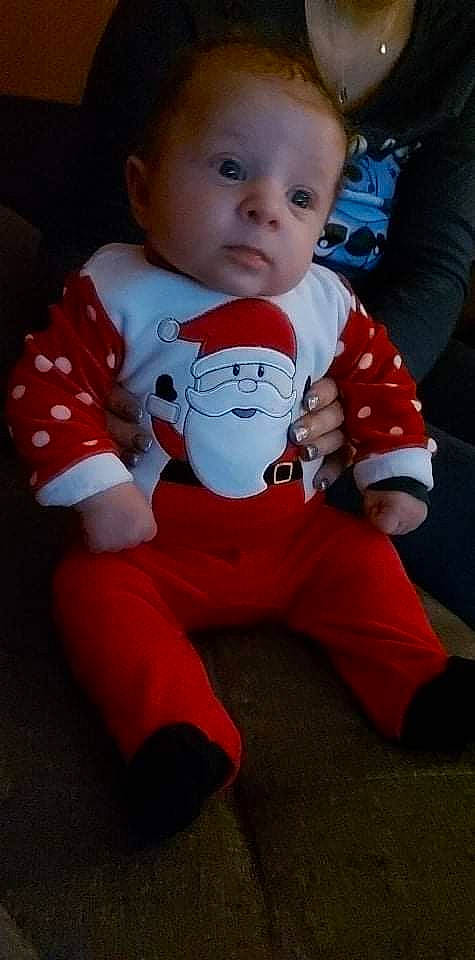 Kayden participe au concours pour gagner de l'argent avec cette photo : baby, baby_toddler_clothing, carmine, cheek, child, christmas, comfort, eye, fictional_character, finger, flooring, fun, happy, orange, pattern, person, red, sitting, sleeve, t_shirt