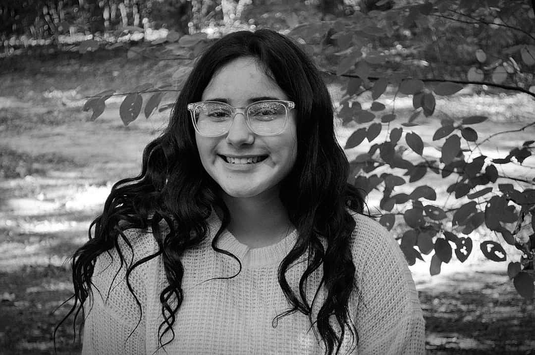 Isabel is registered to the contest to win money with this photo: beauty, black_and_white, black_hair, chest, clothing, eye, eyewear, facial_expression, glasses, happy, iris, joy, leaf, lip, monochrome, monochrome_photography, person, photograph, portrait, portrait_photography