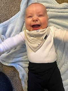 King is registered to the contest to win money with this photo: baby, baby_laughing, baby_toddler_clothing, cheek, child, collar, comfort, eye, face, gesture, happy, head, iris, mouth, nose, person, skin, sleeve, smile, thumb