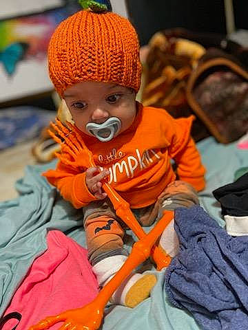 Journee joined the competition — help win amazing prizes! baby, beanie, cap, child, doll, event, fun, hat, head, headgear, headwear, knit_cap, leisure, orange, person, personal_protective_equipment, pumpkin, sitting, toddler, tradition