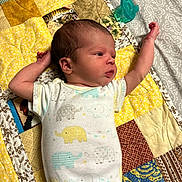 Jerry joined the competition — help win amazing prizes! baby, newborn, infant, child, lying_down, portrait, face, arms, stretching, onesie, elephant_pattern, pacifier, quilt, patchwork, blanket, bed, indoor, sleeping_area, side_profile, family_photo