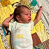 baby, newborn, infant, child, lying_down, portrait, face, arms, stretching, onesie, elephant_pattern, pacifier, quilt, patchwork, blanket, bed, indoor, sleeping_area, side_profile, family_photo