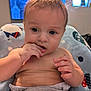 Isaac is registered to the contest to win money with this photo: baby, infant, hand, face, fingers, hair, blanket, clothing, diaper, sitting, indoors, television, expression, skin, cute, child, portrait, curious, cozy, home
