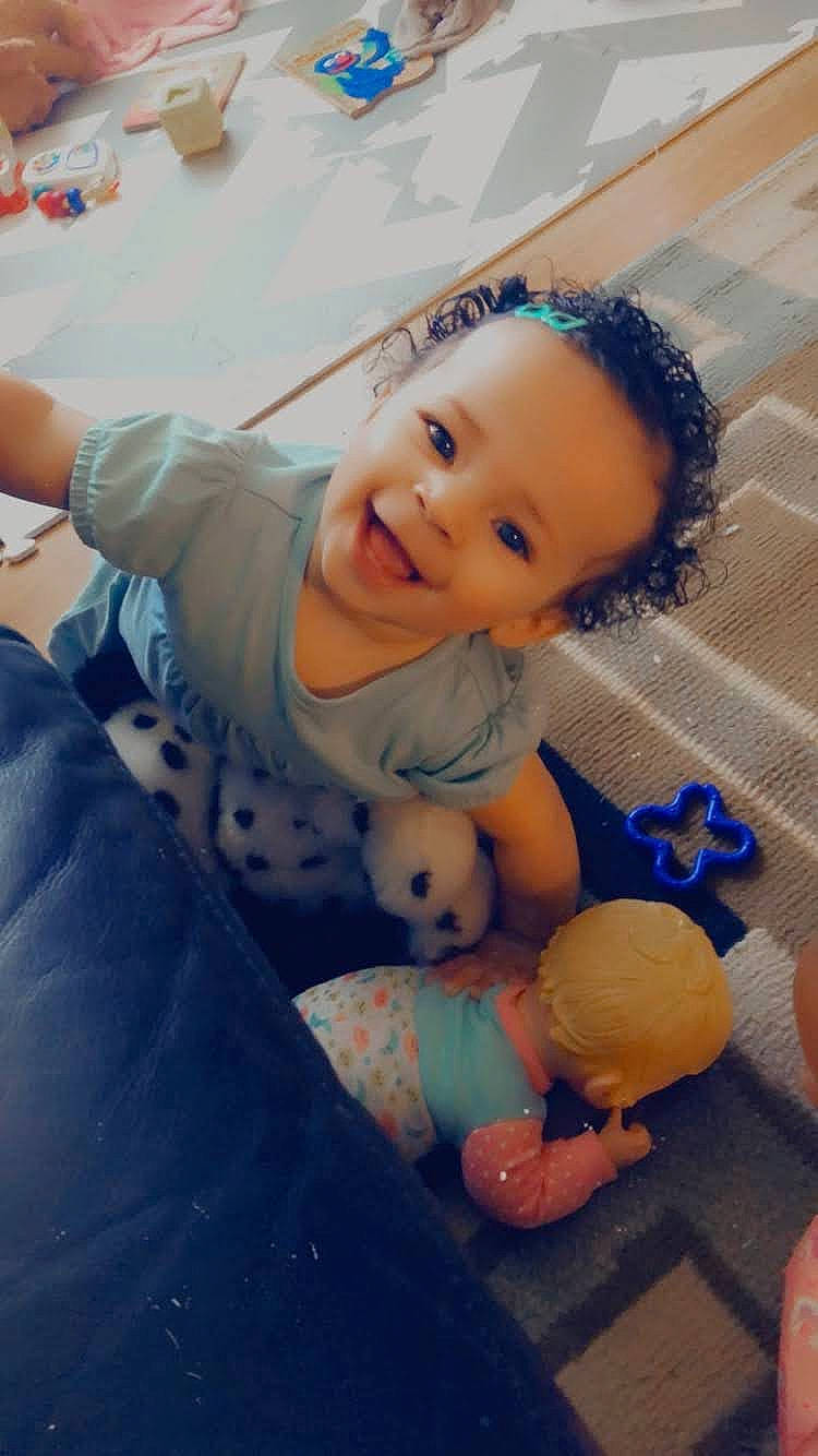 Araeleigh is registered to the contest to win money with this photo: abdomen, baby, baby_toddler_clothing, cheek, child, finger, flooring, fun, happy, head, human_body, joy, leg, mouth, nose, person, sitting, skin, smile, toddler