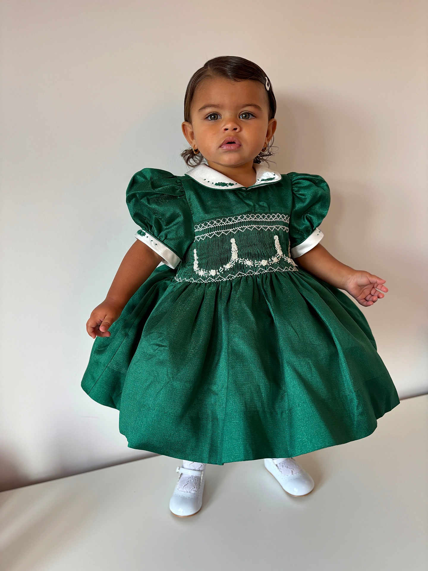 Aniya joined the competition — help win amazing prizes! toddler, child, green_dress, white_shoes, hair_clip, portrait, standing, curious, indoor, fashion, vintage_style, puffed_sleeves, cute, young_child, person, studio, innocence, elegant, minimal_background, footwear