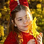 Maria Alice is registered to the contest to win money with this photo: child, girl, red_bow, red_sweater, leaf, autumn, fall_foliage, outdoor, portrait, smiling, long_hair, earrings, nature, sunlight, yellow_leaf, seasonal, cute, young, happy, warm_light