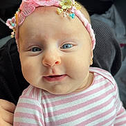 Bella is registered to the contest to win money with this photo: baby, infant, headband, pink, striped_clothing, blue_eyes, face, smile, person, child, cute, portrait, hand, soft_light, indoors, clothing, apparel, skin, newborn, adorable