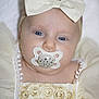 baby, infant, face, pacifier, headband, bow, dress, embroidered, closeup, portrait, cute, child, soft_lighting, white_background, newborn, sleepy, adorable, clothing, hands, skin