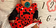 Kanova is registered to the contest to win money with this photo: baby, infant, pacifier, red_dress, ladybug_pattern, black_socks, blanket, floral_pattern, numbers, months_marker, cute, lying_down, indoors, child, portrait, clothing, baby_girl, soft_lighting, close_up, adorable