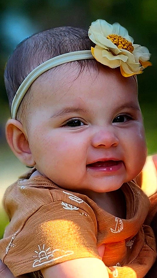 Natalia is registered to the contest to win money with this photo: cheek, chin, dress, eye, eyebrow, face, facial_expression, flower, green, hairstyle, hand, head, headwear, human, human_body, lip, nose, person, plant, product