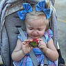 toddler, child, stroller, blue_bows, strawberry, dress, checkered, outdoor, seatbelt, cute, funny_expression, hair_bows, baby, person, summer, food, fruit, small_child, portrait, daylight