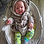 baby, infant, child, hooded_outfit, elephant_costume, baby_rocker, cushion, clothing, green_pants, striped_socks, flooring, indoor, smiling, cute, cozy, seat_belt, wood_floor, plush, person, portrait
