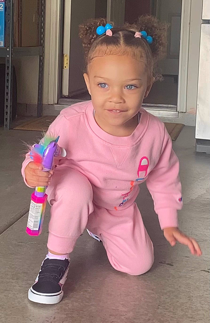 Athena is registered to the contest to win money with this photo: baby, baby_toddler_clothing, blue, cheek, child, door, flooring, foot, fun, happy, human_leg, knee, magenta, person, pink, room, sitting, skin, sleeve, sock