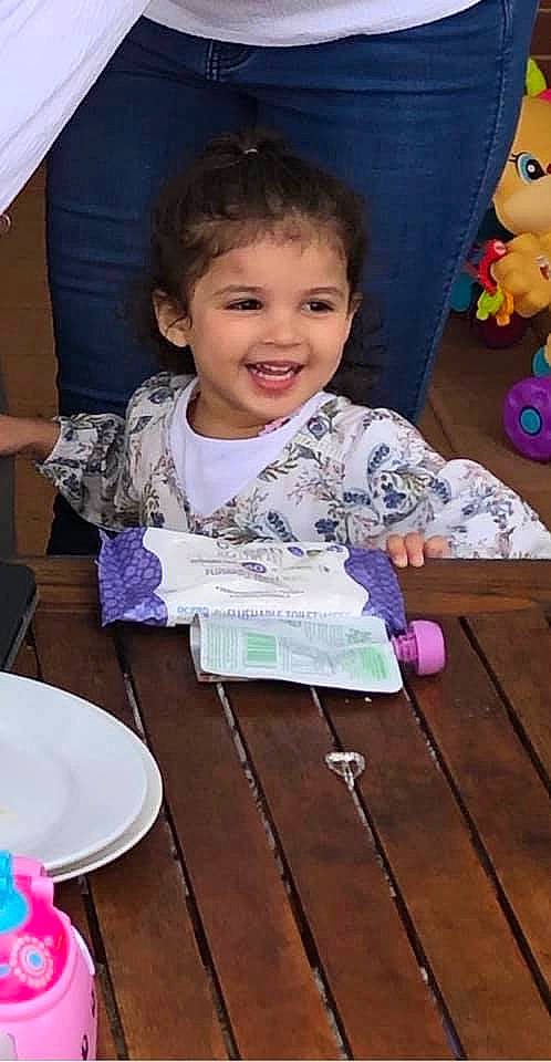 Aisha is registered to the contest to win money with this photo: baby_toddler_clothing, baby_toys, child, dishware, facial_expression, flooring, happy, hardwood, iris, joy, laugh, person, pink, plush, porcelain, stuffed_toy, tent, toddler, toy, wood