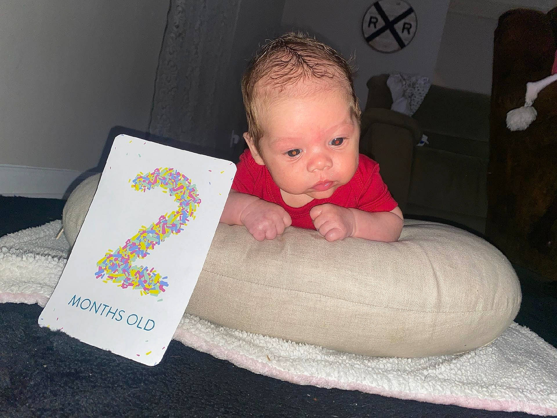 Cylius is registered to the contest to win money with this photo: baby, baby_products, baby_toddler_clothing, cheek, child, comfort, flooring, fun, linens, magenta, pattern, person, product, room, sitting, skin, sleeve, sock, textile, throw_pillow